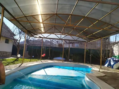 an overhead swimming pool with a metal roof at Къща за гости с минерална вода 