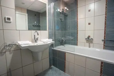 a bathroom with a sink and a tub and a mirror at C Comfort Hotel & Wellness in Hisarya