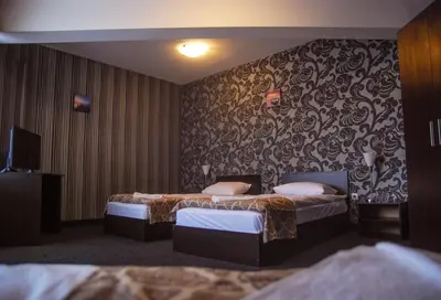 a hotel room with two beds and a wall at Elite Spetema Hotel in Sofia