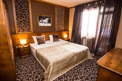 a bedroom with a bed and a window at Elida Family Hotel in Bansko