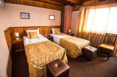a hotel room with two beds and a chair at Elida Family Hotel in Bansko