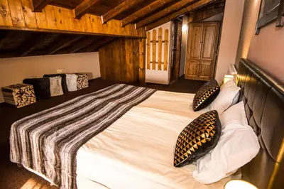 a bedroom with a large white bed with pillows at Elida Family Hotel in Bansko