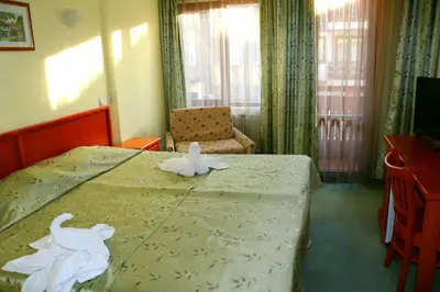 a bedroom with a bed with towels on it at Family Hotel LILI in Bansko