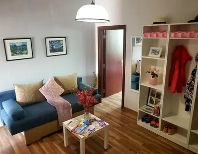 a living room with a blue couch and a table at Plovdiv Top Center 2 Bedroom Apartment, FREE Parking in Plovdiv