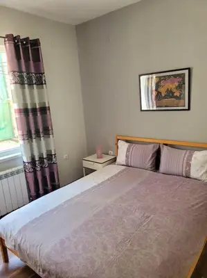 a bedroom with a large bed and a window at Plovdiv Top Center 2 Bedroom Apartment, FREE Parking in Plovdiv