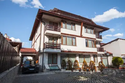 a building with a car parked in front of it at Guest House Ela in Bansko