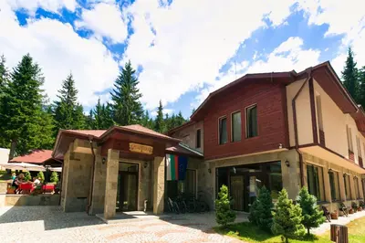 a building with people sitting outside of it at Romantica Forest Guest House in Dospat