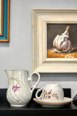 two vases and a plate on a table with a painting at Courthouse Apartments Slavi in Sofia