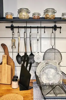 a kitchen counter with utensils hanging on a wall at Courthouse Apartments Slavi in Sofia