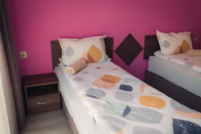 a bedroom with two beds and a pink wall at Villa Galiana in Simitli