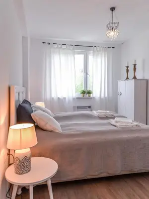 a white bedroom with a large bed and a table at 66 Apartment - Stylish Two Bedroom in Lozenets District by Flat Mаnager in Sofia