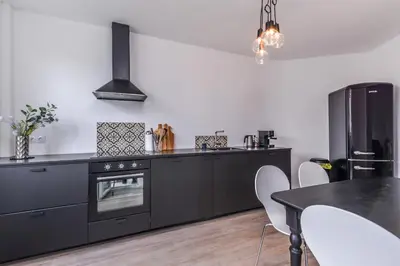 a kitchen with black appliances and a dining table at 66 Apartment - Stylish Two Bedroom in Lozenets District by Flat Mаnager in Sofia