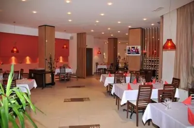 a dining room with white tables and chairs in a restaurant at Studios-Villa Park SV in Borovets