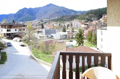 a balcony with a view of a city and mountains at СТАИ ЗА ГОСТИ МЗ-ДЕВИН in Devin
