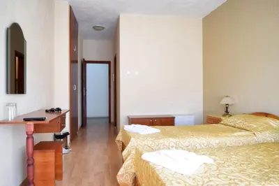a hotel room with two beds and a desk at СТАИ ЗА ГОСТИ МЗ-ДЕВИН in Devin