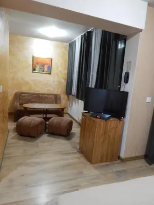 a living room with a couch and a television at Rio Family Hotel in Blagoevgrad