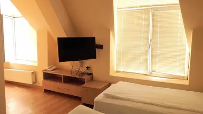 a bedroom with a bed and a flat screen tv at Rio Family Hotel in Blagoevgrad