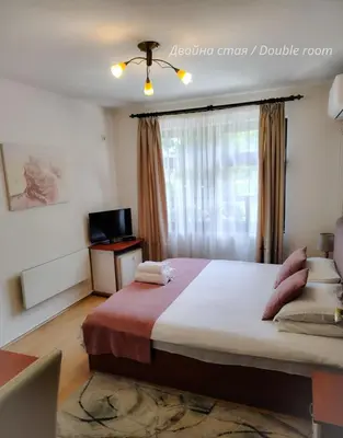 a bedroom with a large bed and a window at Petkov Family Hotel in Blagoevgrad
