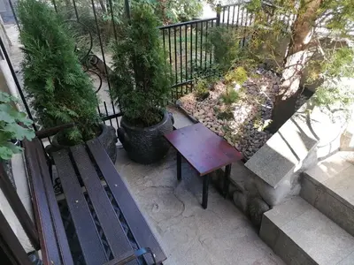 a wooden bench sitting on a balcony with plants at Petkov Family Hotel in Blagoevgrad