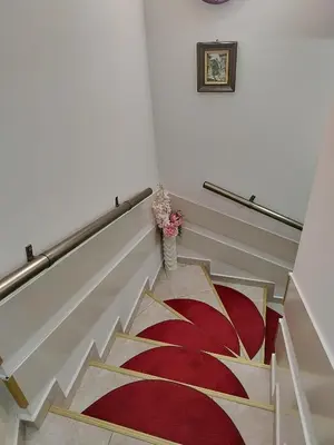 a stairway with a red and gold rug at Petkov Family Hotel in Blagoevgrad