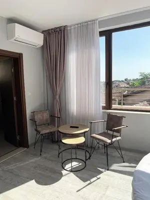 a room with a table and chairs and a window at Clepsydra Residence in Plovdiv
