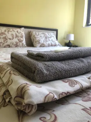 a bed with a blanket on top of it at Апартамент ТЕА in Sandanski