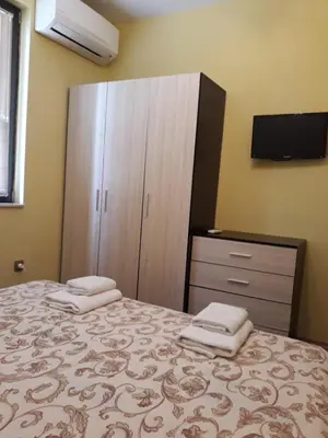 a bedroom with a bed and a dresser at Апартамент ТЕА in Sandanski