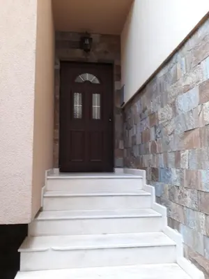 a front door of a house with stairs at Апартамент ТЕА in Sandanski