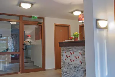 a lobby with a glass door and a brick wall at The Poppies House in Pamporovo