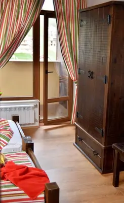 a bedroom with a bed and a dresser and a window at The Poppies House in Pamporovo