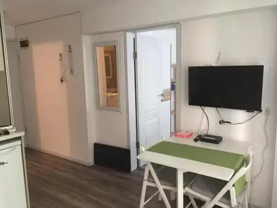 a room with a television and a desk with a table at Apartment Button in downtown in Sofia