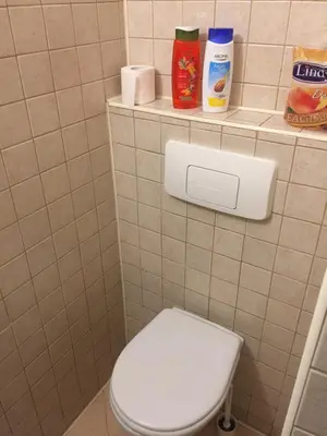 a bathroom with a toilet and a shelf with toiletries at Apartment Button in downtown in Sofia