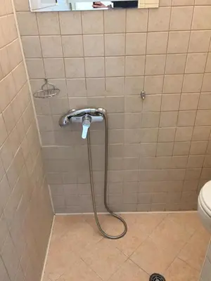 a shower with a hose in a bathroom with a toilet at Apartment Button in downtown in Sofia