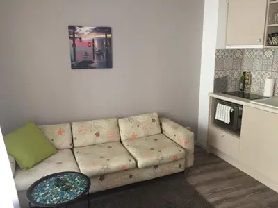 a living room with a couch and a table at Apartment Button in downtown in Sofia