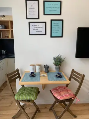 a wooden table with two chairs in a kitchen at Campbell's central apartment in Sofia