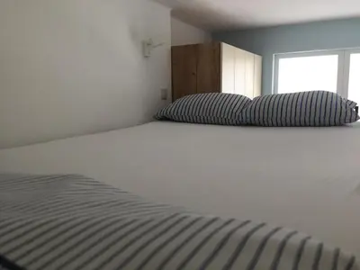a bedroom with a large white bed with a window at Campbell's central apartment in Sofia