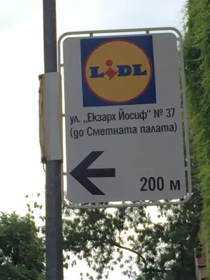 a street sign on a pole with an arrow at Campbell's central apartment in Sofia