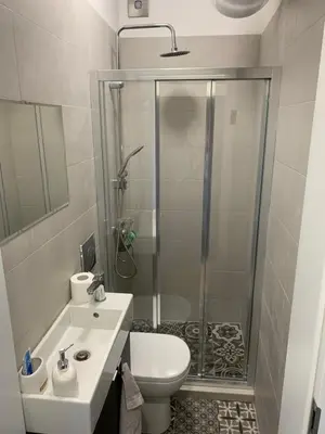 a bathroom with a shower and a toilet and a sink at Campbell's central apartment in Sofia