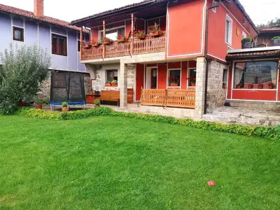 a house with a green yard in front of it at Радкината къща in Koprivshtitsa