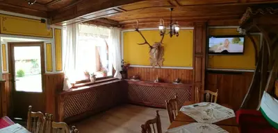 a dining room with a table and a tv on the wall at Радкината къща in Koprivshtitsa