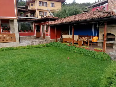 a house with a yard with green grass at Радкината къща in Koprivshtitsa