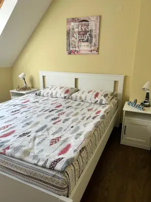 a bedroom with a bed and two night stands at Roma Apartment in Sandanski