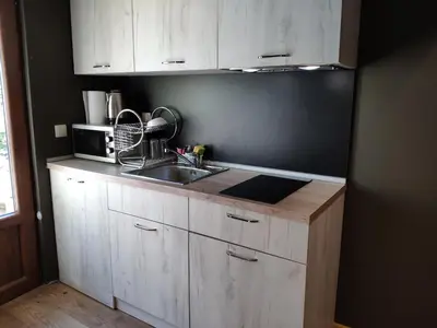 a kitchen with white cabinets and a sink and a microwave at Urban House in Sofia