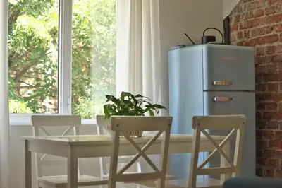 a dining room with a table and a blue refrigerator at The FlyingTheatre Suites in Plovdiv