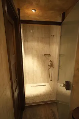 a bathroom with a shower with a glass door at The FlyingTheatre Suites in Plovdiv