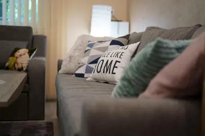a couch with pillows and a baby sleeping on it at The Place -Apartments in Plovdiv, with private parking in Plovdiv
