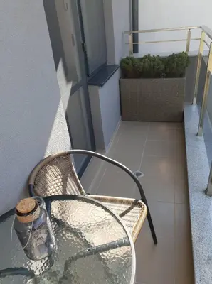 a glass chair with a bottle sitting on a table at The Place -Apartments in Plovdiv, with private parking in Plovdiv