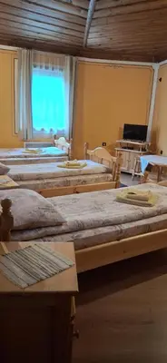 a room with several beds in it with a window at Стаи за гости Дончо Войвода in Koprivshtitsa