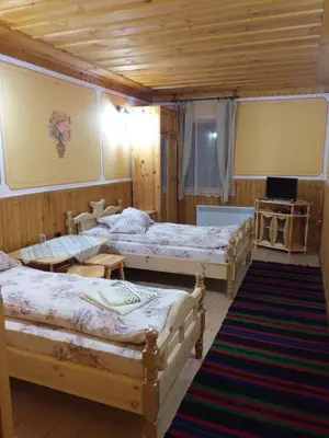 a bedroom with three beds in a room at Стаи за гости Дончо Войвода in Koprivshtitsa