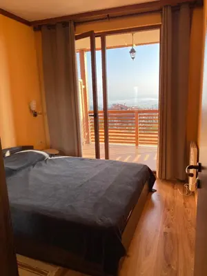 a bedroom with a bed and a large window at Private Apartment Maxim in Bansko